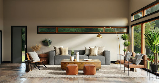 A living room with wood floors and windows looking out into green space.