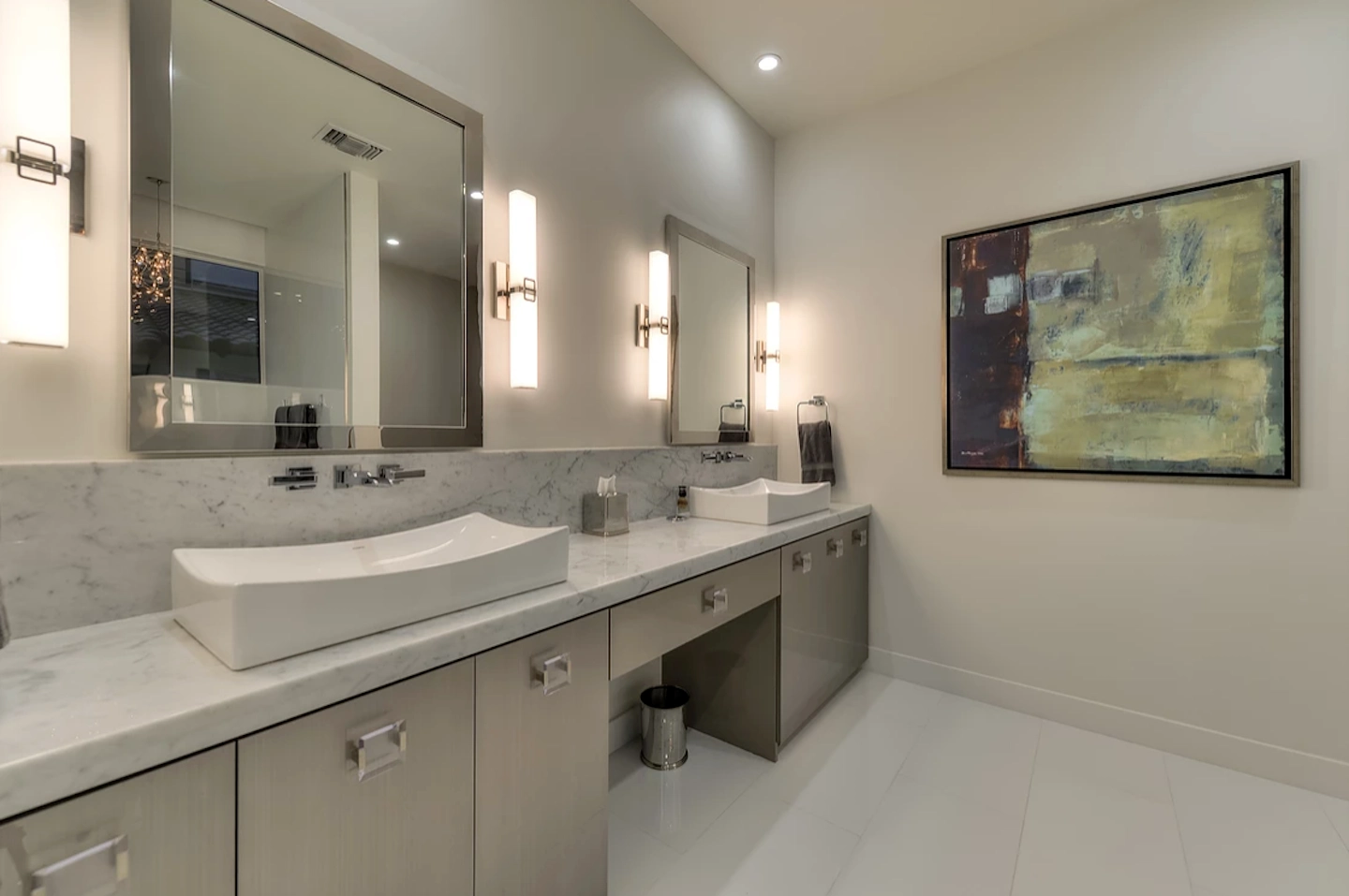 A spacious double vanity with a pair of mirrors. The vanity is a light silver tone and includes seven drawers for storage.